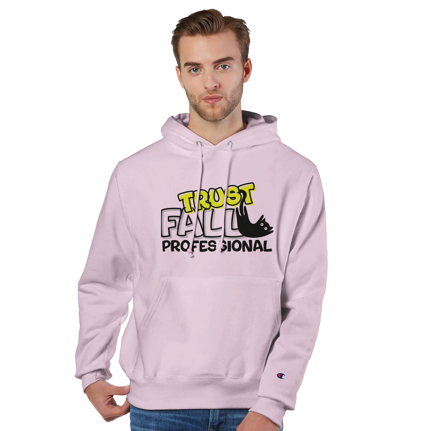 Model wearing a body blush Champion pullover hoodie with the “Trust Fall Professional” graphic on the front, featuring bold yellow and black lettering and a falling cat illustration.