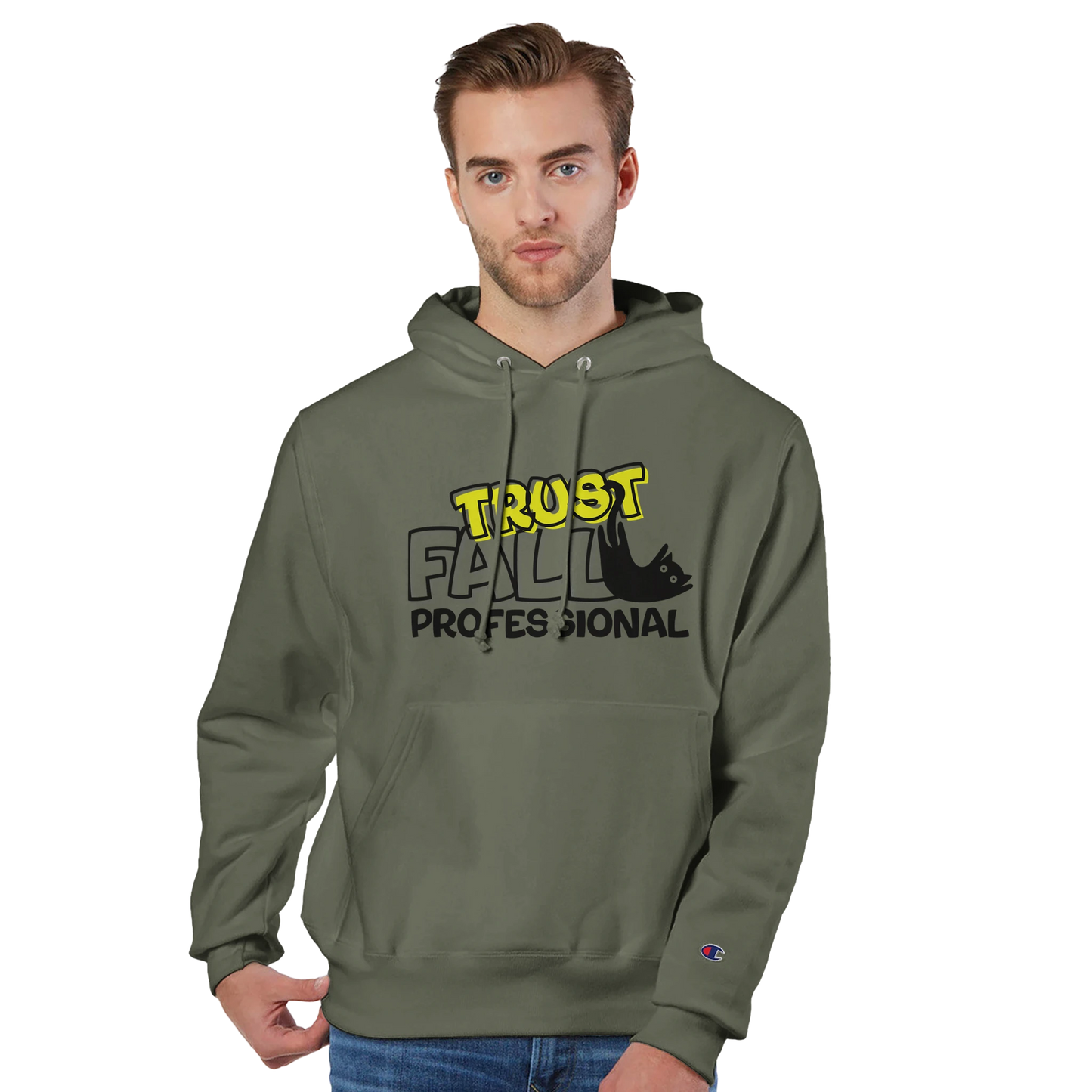 Model wearing a fresh olive Champion pullover hoodie with the “Trust Fall Professional” graphic on the front, featuring bold yellow and black lettering and a falling cat illustration.