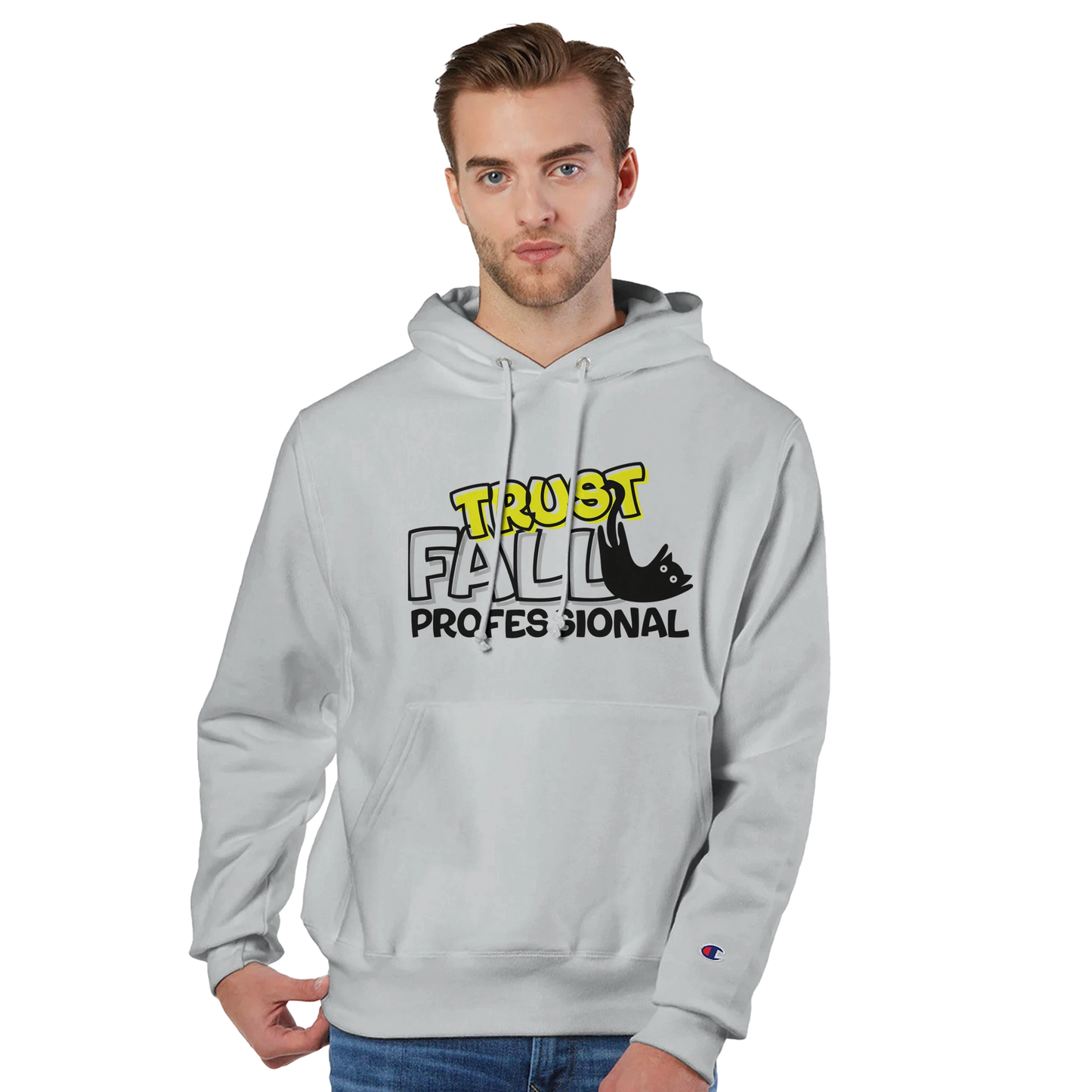 Model wearing a silver grey Champion pullover hoodie with the “Trust Fall Professional” graphic on the front, featuring bold yellow and black lettering and a falling cat illustration.