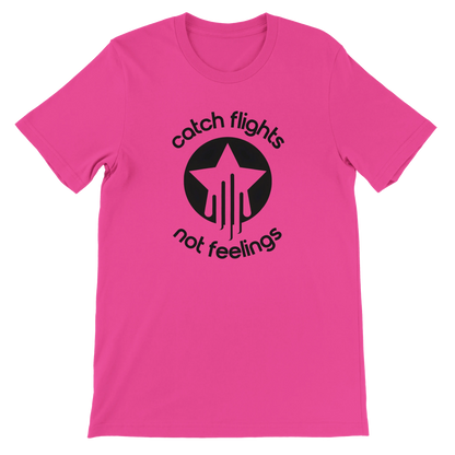 Charity pink unisex t-shirt with a bold black graphic that reads “catch flights not feelings” curved around a star and streak icon, printed on the chest.