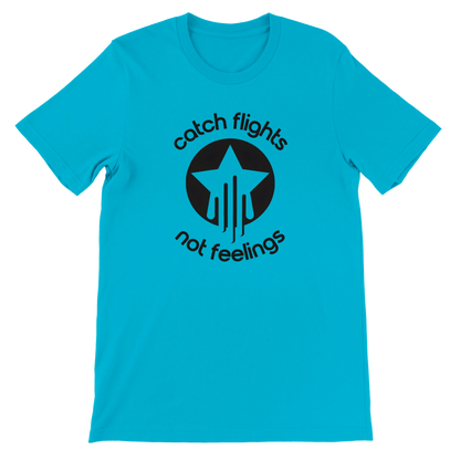 Turquoise unisex t-shirt with a bold black graphic that reads “catch flights not feelings” curved around a star and streak icon, printed on the chest.