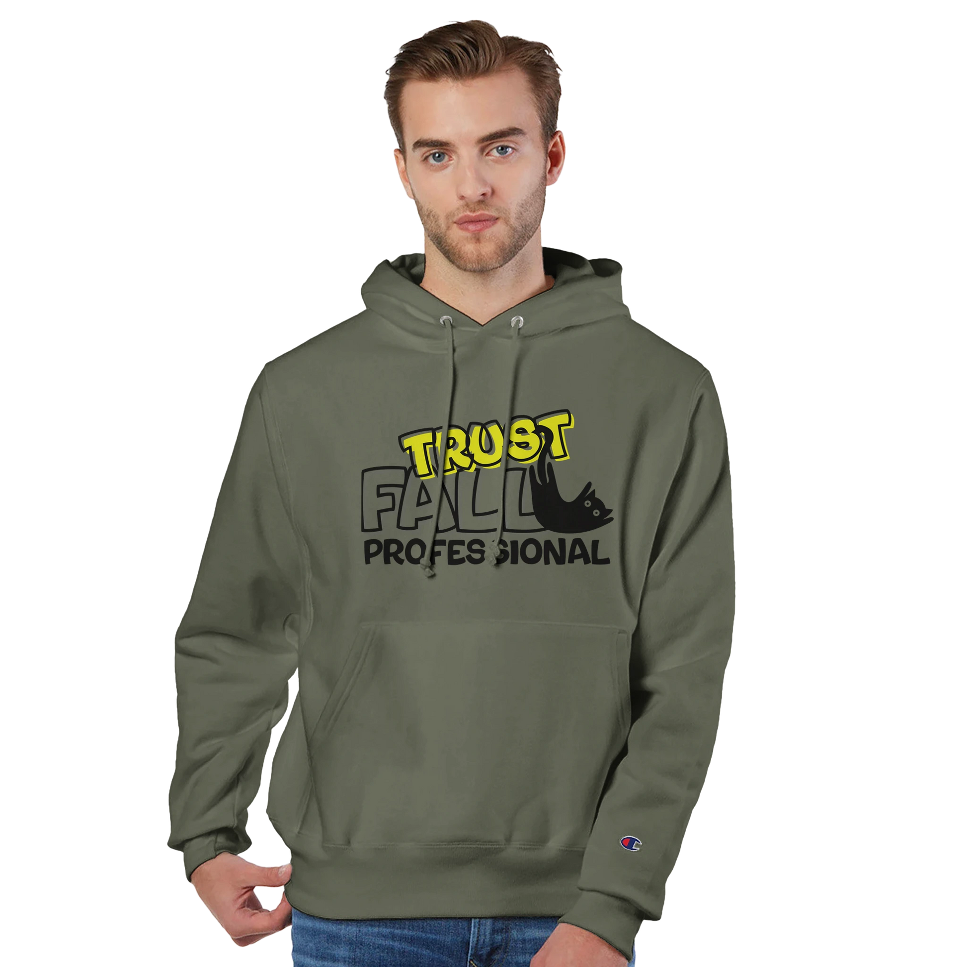 Model wearing a fresh olive Champion pullover hoodie with the “Trust Fall Professional” graphic on the front, featuring bold yellow and black lettering and a falling cat illustration.