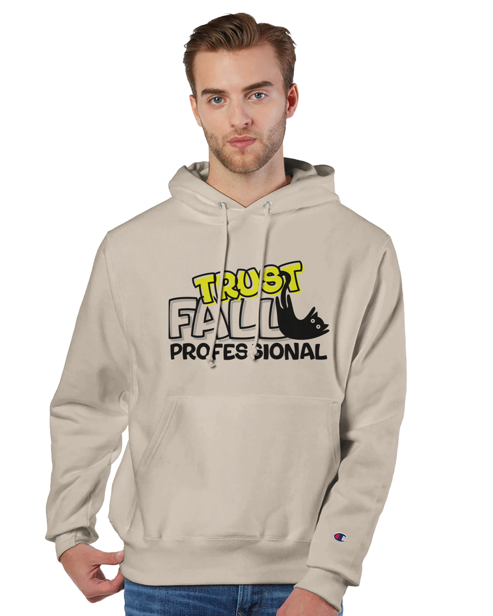 Model wearing a sand Champion pullover hoodie with the “Trust Fall Professional” graphic on the front, featuring bold yellow and black lettering and a falling cat illustration.